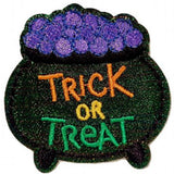 A patch with a cauldron design, featuring the text 'TRICK OR TREAT' and a purple ingredient pot on top, all embroidered in a shiny fabric.