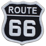 A shield-shaped patch with a white background and black text that reads 'ROUTE 66'.