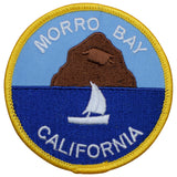 A round patch featuring an embroidered image of Morro Rock, with 'MORRO BAY CALIFORNIA' text and a sailboat on a blue background, designed for iron-on application.