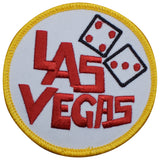 A round embroidered patch with 'LAS VEGAS' written in red and black letters, accompanied by images of dice, against a white background with a yellow border.