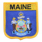 A shield-shaped embroidered patch with the word 'MAINE' at the top and bottom. 