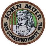 An embroidered patch featuring John Muir, the conservationist, with a green and beige color scheme.