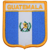 A shield-shaped embroidered patch with the words 'GUATEMALA' at the top. The patch features a white vertical stripe with a green and gold emblem on the left, and a blue vertical stripe with white horizontal stripes on the right.