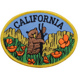 A patch featuring an illustration of a bear cub with a background of poppy flowers and the text 'CALIFORNIA'.