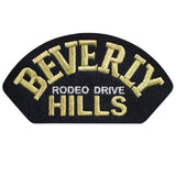 A patch with the text 'BEVERLY HILLS RODEO DRIVE' embroidered in gold 