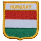 A shield-shaped embroidered patch with the text 'HUNGARY' and horizontal stripes in red, white, and green colors, bordered with a yellow edge.