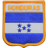 A shield-shaped embroidered patch with a blue background, featuring a white cross and the text 'HONDURAS' along with stars.