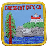 A patch featuring an illustration of a lighthouse, tree, and surrounding landscape with the text 'CRESCENT CITY, CA'.