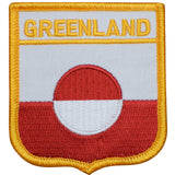 A shield-shaped embroidered patch with the text 'GREENLAND' at the top, a large red and white circle in the center, and a yellow border.