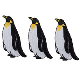 Three penguin applique patches intended to be ironed onto fabric.