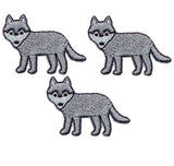 Three grey mini wolf applique patches designed as badges, intended to be ironed onto fabric.