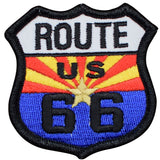 A shield-shaped patch with 'ROUTE US 66' text and a radiant star design in the center, predominantly in red, blue, and yellow colors.