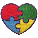 A heart-shaped patch with a puzzle piece design, featuring colors red, blue, green, and yellow, with a purple outline, representing autism awareness.