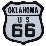 A shield-shaped embroidered patch with 'OKLAHOMA US 66' text, predominantly white with a black border.