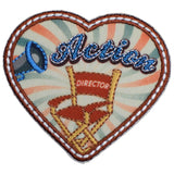 A heart-shaped embroidered patch with the words 'Action Director' and an illustration of a movie projector and chairs.