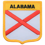 A shield-shaped patch with a red cross on a white background with the text 'ALABAMA' across the top. The patch has a yellow border.