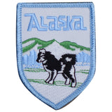 A shield-shaped patch featuring an illustration of a husky, mountains, and the text 'Alaska'.