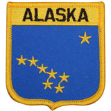 A shield-shaped embroidered patch with the word 'Alaska' across the top and a pattern of stars across a blue background.