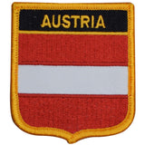 A shield-shaped embroidered patch with the text 'AUSTRIA' and the flag colors of Austria, primarily red and white, with a yellow border.