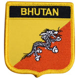 A shield-shaped embroidered patch with a depiction of a dragon and the text 'BHUTAN' on a yellow background.