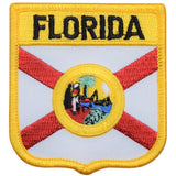 A shield-shaped embroidered patch with the text 'FLORIDA' at the top, featuring a emblem and flag elements in the center, with red and white diagonal stripes, and a yellow border.