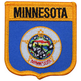 A shield-shaped embroidered patch with the text 'MINNESOTA' at the top, featuring an emblem in the center, surrounded by a blue border with a yellow trim.