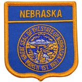 A shield-shaped blue patch with the text 'NEBRASKA' on it, featuring an embroidered seal of Nebraska in gold and orange.