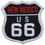 A shield-shaped embroidered patch with the text 'NEW MEXICO US 66' on a black background with a white outlined border.
