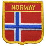 A shield-shaped embroidered patch with the text 'NORWAY' across the top. The patch features a red background with a blue and white cross, bordered by a yellow line.