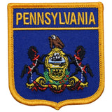 A shield-shaped embroidered patch with a blue field featuring the state emblem of Pennsylvania, including an eagle and the state motto. The patch has a yellow border and the text 'Pennsylvania' appears at the top.