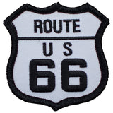 A shield-shaped patch with 'ROUTE US 66' text in black on a white background, bordered with black edging.