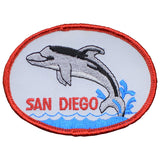 An oval-shaped embroidered patch featuring an illustration of a dolphin with the text 'SAN DIEGO' below it, bordered by a red and blue design.