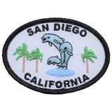An oval-shaped patch featuring text 'SAN DIEGO CALIFORNIA' with an image of two dolphins and palm trees.