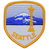 A shield-shaped patch with a depiction of Mount Rainier and the Space Needle, featuring the text 'Seattle' on a blue and gold background.