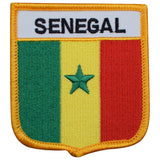 A shield-shaped embroidered patch with vertical stripes of green, yellow, and red, topped with a star and the text 'SENEGAL'.