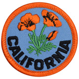 A round embroidered patch featuring a floral design with orange and black colors and the word 'CALIFORNIA' below it.