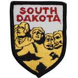 A shield-shaped embroidered patch with the text 'SOUTH DAKOTA' and an image of Mount Rushmore.