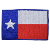 A small embroidered patch depicting the Texas flag with a star on a blue background, red horizontal stripe, and a white horizontal stripe.