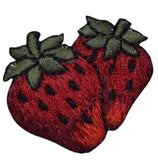 A pair of embroidered strawberry patches with green stems on a red berry background.