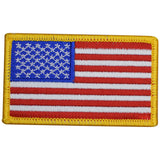 A patch with the design of the United States of America flag, featuring red and white stripes with a blue field and white stars, bordered by a yellow edge.